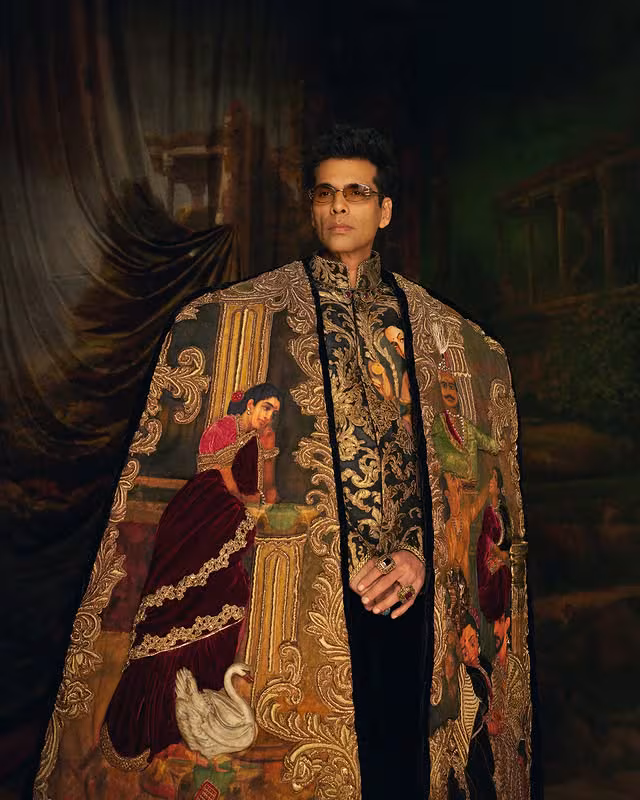 Karan Johar Makes Met Gala Debut In A Hand-Painted Tribute To Raja Ravi Varma Published By : NISHA DUBEY News18.com Edited By: Priyanka Das Last Updated: May 05, 2026, 09:00 IST Karan Johar made a striking Met Gala 2026 debut in a Manish Malhotra ensemble inspired by Raja Ravi Varma. + Follow usOn Google 1/7 At the Met Gala 2026, Karan Johar didn’t just walk the red carpet, he told a story. Known for his larger-than-life cinematic vision, the filmmaker brought that same storytelling lens to fashion, turning his debut into a moving piece of art inspired by Raja Ravi Varma. In a night celebrating “Fashion is Art,” Johar didn’t just follow the theme; he embodied it, proving that storytelling doesn’t stop at the screen. Known for his larger-than-life cinematic vision, Karan Johar brought the same storytelling lens to fashion, turning his Met Gala debut into a moving piece of art inspired by Raja Ravi Varma. In a night celebrating “Fashion is Art,” Johar didn’t just follow the theme; he embodied it, proving that storytelling doesn’t stop at the screen. (Image: Instagrama/@karanjohar) + Follow usOn Google 2/7 For Karan Johar, fashion has always been more than clothing. Drawing from his filmmaking philosophy, his Met Gala look asked the same questions his films do: what does it say, and what does it make you feel? The result was an outfit that felt deeply personal and layered with meaning. For Karan Johar, fashion has always been more than clothing. Drawing from his filmmaking philosophy, his Met Gala 2026 look asked the same questions his films do: what does it say, and what does it make you feel? The result was an outfit that felt deeply personal and layered with meaning. (Image: Instagram/@karanjohar) ADVERTISEMENT  3/7 Designed by Manish Malhotra and styled by Eka Lakhani, the ensemble paid homage to Raja Ravi Varma, the artist known for shaping India’s visual identity. His iconic imagery – lotuses, swans, and classical motifs – was translated onto fabric, turning the outfit into a wearable canvas. Designed by Manish Malhotra and styled by Eka Lakhani, the ensemble paid homage to Raja Ravi Varma, the artist known for shaping India’s visual identity. His iconic imagery – lotuses, swans, and classical motifs – was translated onto fabric, turning the outfit into a wearable canvas. (Image: Instagram/@karanjohar) Add News18 as Preferred Source on Google 4/7 What truly set the look apart was its commitment to authenticity. Every motif was painted entirely by hand, no prints, no digital shortcuts. Even the lining of the jacket, hidden from plain sight, was hand-painted. It was a quiet detail, but one that spoke volumes about the dedication to craft. What truly set the look apart was its commitment to authenticity. Every motif was painted entirely by hand, no prints, no digital shortcuts. Even the lining of the jacket, hidden from plain sight, was hand-painted. It was a quiet detail, but one that spoke volumes about the dedication to craft. (Image: Instagram/@karanjohar) ADVERTISEMENT  5/7 The ensemble was brought to life by a team of artisans who spent over 5,600 hours across 86 days perfecting every detail. From painting to embroidery, the process was as intricate as the final look, reflecting a deep respect for traditional techniques. The ensemble was brought to life by a team of artisans who spent over 5,600 hours across 86 days perfecting every detail. From painting to embroidery, the process was as intricate as the final look, reflecting a deep respect for traditional techniques. (Image: Instagram/@karanjohar) 6/7 The borders weren’t just embroidered, they were built. Using rubberised bases layered with zardozi, the motifs had a raised, three-dimensional quality, almost like thick paint on canvas. Pillars, lotuses, and swans appeared to emerge from the fabric, adding depth and texture. The embroidery was treated with acrylic and oil finishes, then varnished to mimic the glow of an actual painting. As Johar moved, the outfit caught light in a way that felt almost cinematic. The borders weren’t just embroidered, they were built. Using rubberised bases layered with zardozi, the motifs had a raised, three-dimensional quality, almost like thick paint on canvas. Pillars, lotuses, and swans appeared to emerge from the fabric, adding depth and texture. The embroidery was treated with acrylic and oil finishes, then varnished to mimic the glow of an actual painting. As Johar moved, the outfit caught light in a way that felt almost cinematic. (Image: Instagram/@karanjohar) ADVERTISEMENT  7/7 Johar was clear about one thing: no compromises. Referencing Raja Ravi Varma meant honouring his process, which is why every detail had to be done by hand. In an age of digital fashion, this insistence on authenticity made the look stand out even more. Much like his films, where costumes play a key role in storytelling, this look used fabric, drape, and detail to communicate emotion and character. It wasn’t just about looking grand, it was about saying something meaningful through fashion. Johar was clear about one thing: no compromises. Referencing Raja Ravi Varma meant honouring his process, which is why every detail had to be done by hand. In an age of digital fashion, this insistence on authenticity made the look stand out even more. Much like his films, where costumes play a key role in storytelling, this look used fabric, drape, and detail to communicate emotion and character. It wasn’t just about looking grand, it was about saying something meaningful through fashion. (Image: Instagram/@karanjohar)